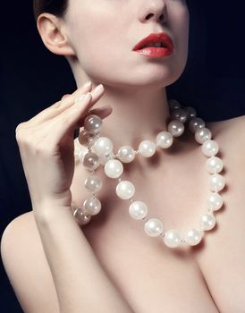 Topless young woman with pearls necklace