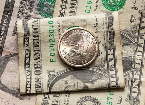 Contrast of the US dollar and half dollar coin with a worn paper bill