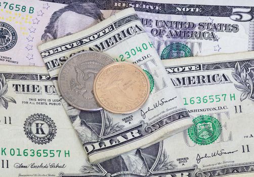 Contrast of the US dollar and half dollar coin with a worn paper bill