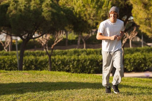 young handsome man jogging in public park