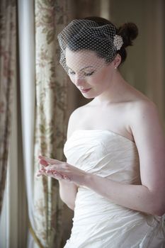 pretty bride in wedding dress looking at her wedding ring