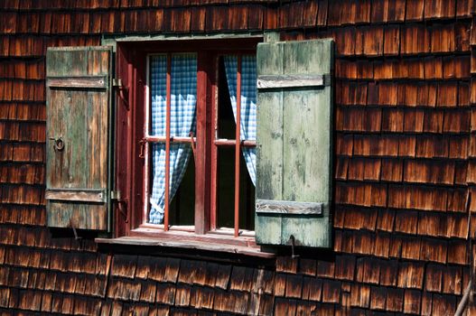 window of idyllic wood panelled alpine cottage in bavarian alps