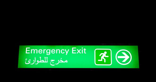 Emergency exit sign in an international airport in Middle East with Arabic information