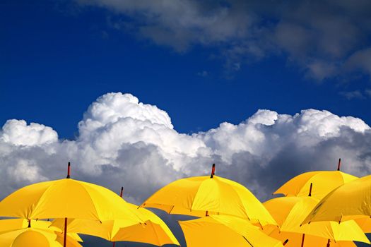 yellow umbrellas on cloudy background
