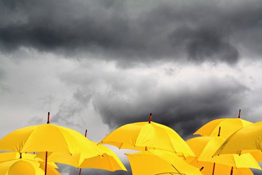 yellow umbrellas on cloudy background