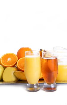 Apple and orange fruits with juice on tray over white