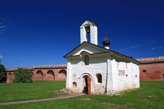 aging blanching church amongst green herb