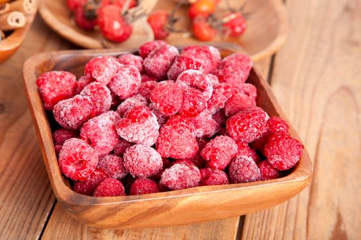 frozen raspberries in the wooden bowl