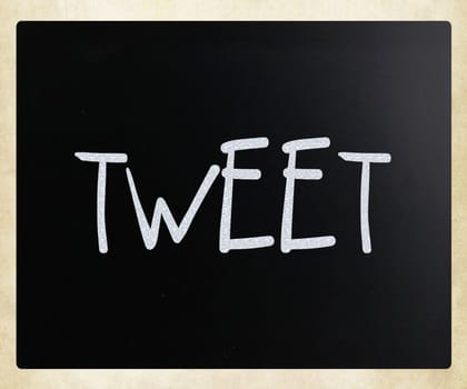 "Tweet" handwritten with white chalk on a blackboard.