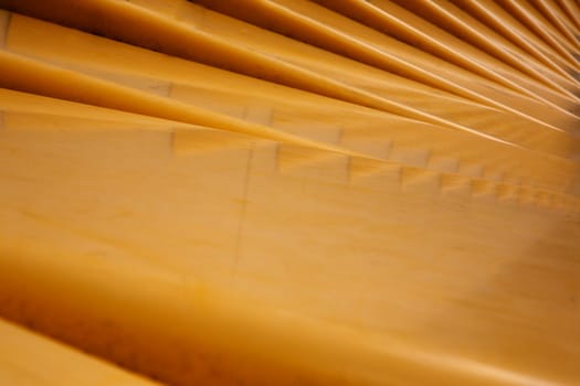 Abstract shot of a mustard yellow curved stepped surface