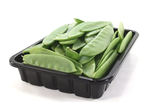 fresh green Sugar peas in a bowl on a light background