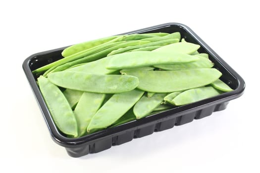 fresh Sugar peas in a bowl on a light background