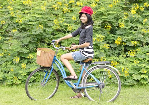 Portrait of pretty young woman with bicycle in a park smiling - Outdoor 