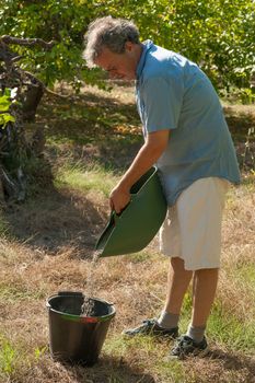 Agricultural worker preparing a bucket with fertilizer