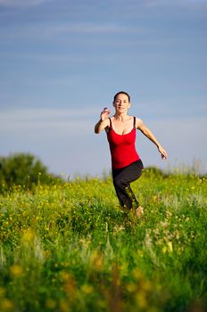 Sport woman running on a sunset field