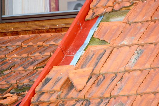 damaged tiles on roof after a heavy summer storm