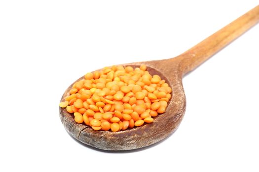 bunch of red lentil in old spoon over white