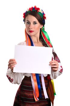 Young Ukrainian woman in national costume showing empty sheet of paper. Isolated on white background