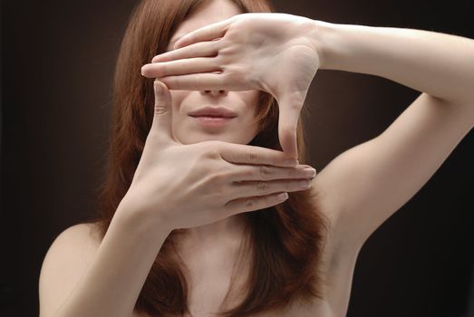 Woman's hand showing crop symbol over her face
