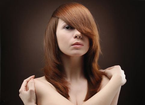 Portrait of young beautiful woman folding arms round her shoulders