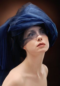 Portrait of young beautiful woman folding fabric round her head