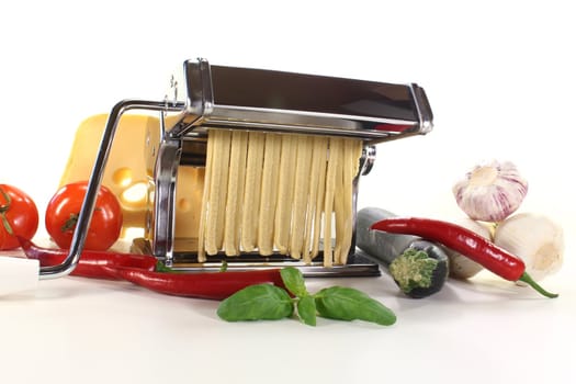 tagliatelle in a pasta machine with vegetables and basil