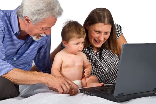 mother and grandfather with baby play with pc