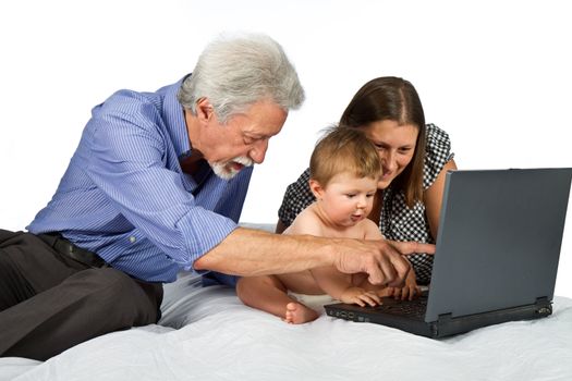 mother and grandfather with baby play with pc