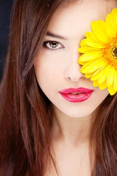 Yellow daisy over pretty woman's eye