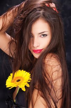 Pretty woman with long hair and yellow daisy