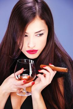 Portrait of a pretty woman with pelt, holding glass of brandy and cigar