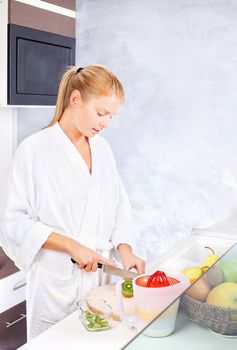 pretty woman making fruit salad in kitchen