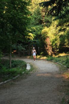 Beauty young teenage girl running across green morning park