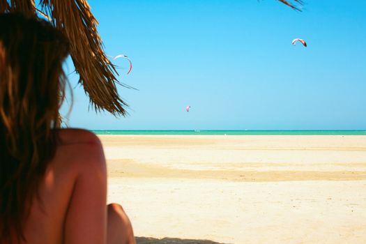 Woman relaxing on the beach and looking at sea