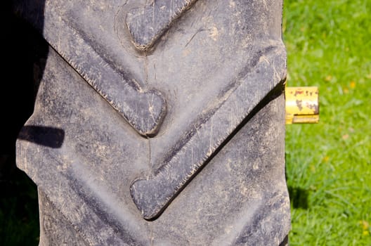 Tractor tire protector closeup background. Agricultural machinery part fragment.