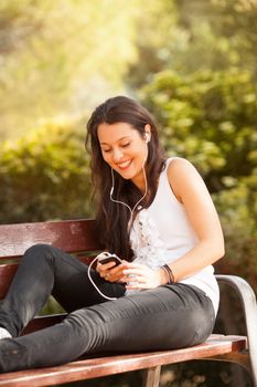 young latin woman using celphone outdoors