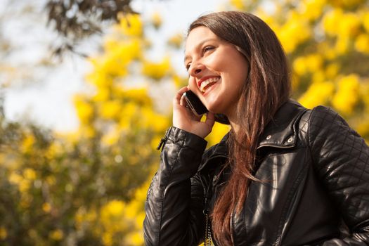 young latin woman using celphone outdoors