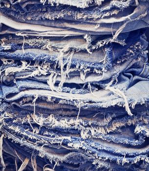 A stack of torn old jeans - background