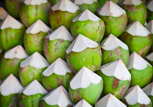 Green coconuts with juice inside, on the counter