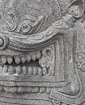 The stone head of an ancient Buddhist deity close-up