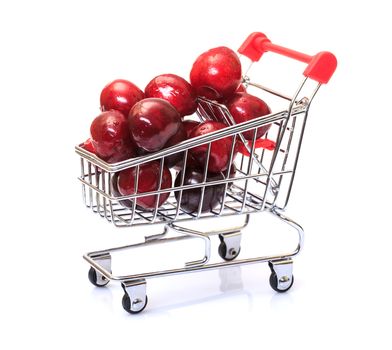 Shopping Cart with Ripe Cherries, closeup on a white background