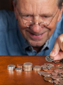 Senior retired caucasian man counting out cash into piles