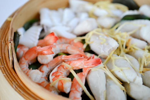 close-up of steamed seafood in a bamboo basket
