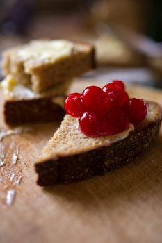 Small sliced piece of wheat bread with cranberries on the wooden table. Shallow DOF