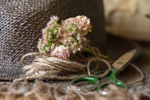 Still life of scissors,small bouqet with flowers and cord