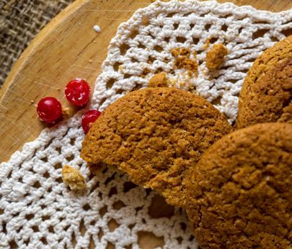 Crumpled tasty oatmeal cookies with cranberries on knitting cloth.Shallow DOF