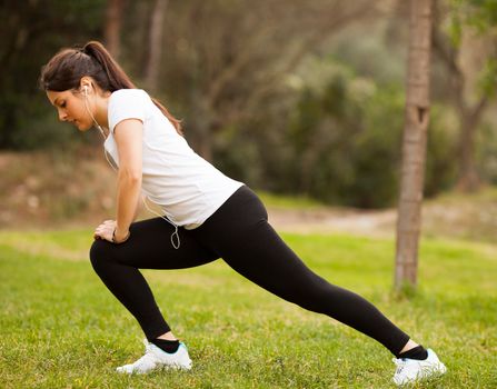 young beautiful woman stretching outdoors