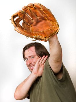 Ball is comming at the guy and he is afraid of it. Has baseball glove up as well as his arm to stop it from hitting his face.Focus is fairly shallow and on the glove though man behind still is enough focus to be usefull. Image isolated against a white background