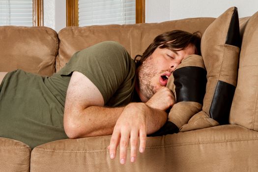 He is asleep mouth open and arm just flung over the side of the couch. 
