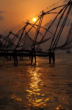 Sunset over Chinese Fishing nets and boat in Cochin (Kochi), Kerala, India.